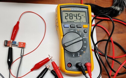A multimeter
              connected to a voltage divider across the left and right audio
              outputs of a headphone jack showing 284.5 mV AC.